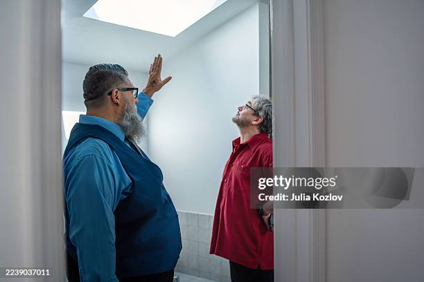 customer and broker discussing skylight feature while touring home in pennsylvania. - study guide stock pictures, royalty-free photos & images