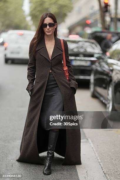 Gala Gonzalez is seen wearing sunglasses, a floor length coat, grey midi skirt, black boots and carrying a shoulder bag outside of Giambattista Valli...