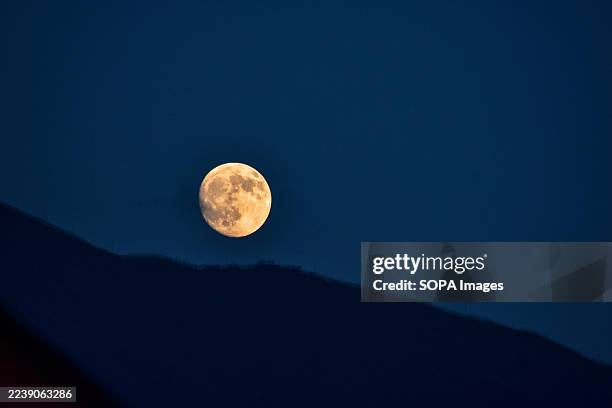 The full harvest moon also known as October moon rises over the Zabarwan hills in Srinagar, the summer capital of Jammu and Kashmir.