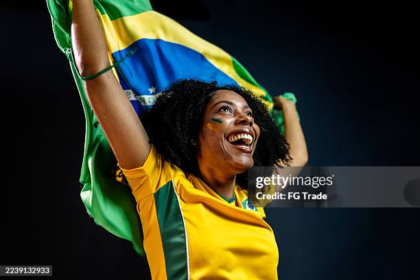 excited brazilian soccer fan celebrating with flag - international soccer event stock pictures, royalty-free photos & images