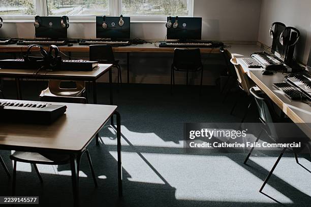 modern music classroom with instruments and computers for creative learning in the afternoon light - alfombra raton fotografías e imágenes de stock