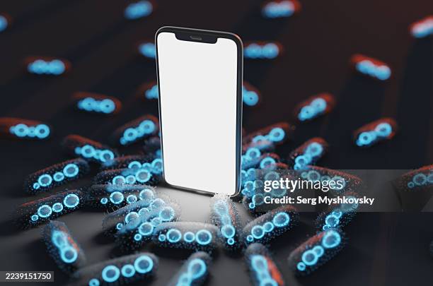 lots of bacteria around a smartphone on a black table. - enterobacter aerogenes stock pictures, royalty-free photos & images