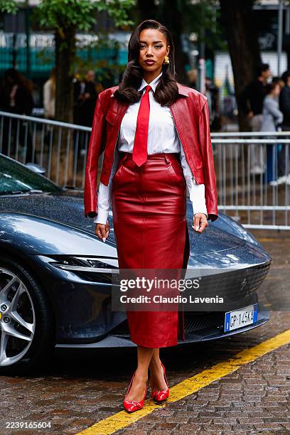 Guest wears white shirt with red beck tie, black leather jacket, red leather pencil skirt, red heels, outside Ferrari, during the Milan Fashion Week...