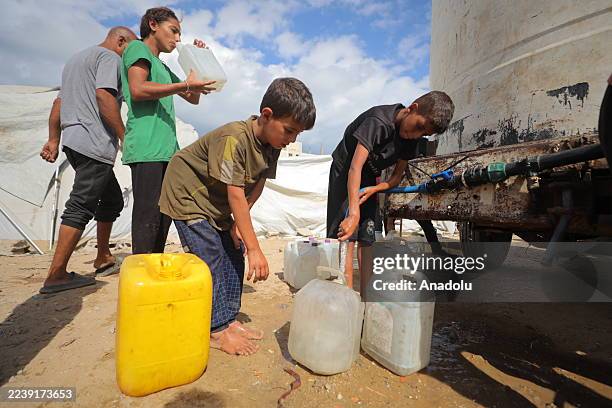 Palestinians wait in line for clean water distributed by chariyable organizations in Az-Zawayda, Gaza on October 06, 2025.