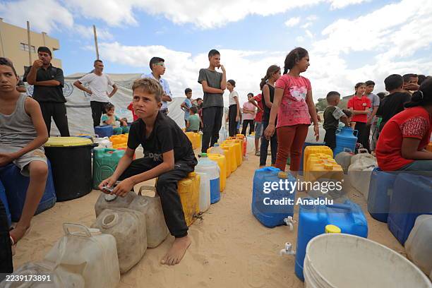 Palestinians wait in line for clean water distributed by chariyable organizations in Az-Zawayda, Gaza on October 06, 2025.