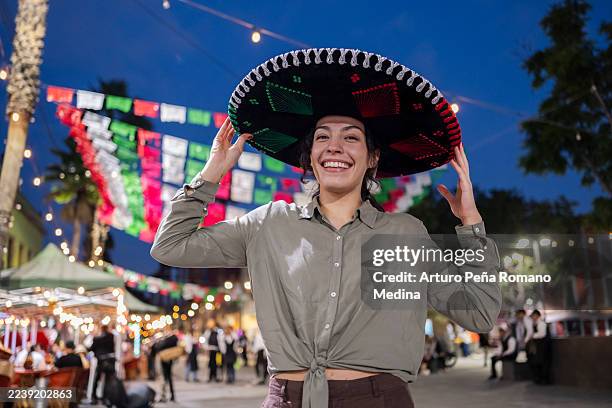 joven mexicana disfrutando de las fiestas patrias y el tequila mientras usa ropa tradicional como un sombrero de charro. - estado de méxico fotografías e imágenes de stock