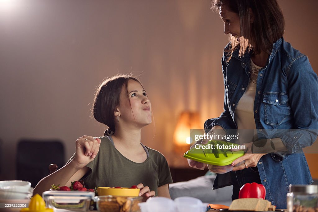 Mother and daughter cooking together at home, preparing healthy snacks in a cozy kitchen today