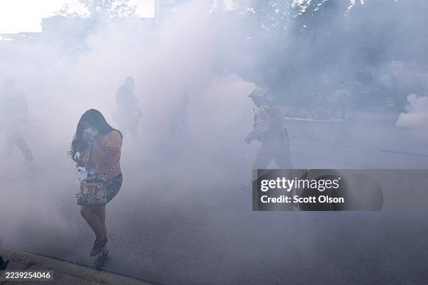Tear gas fills the air after it was used by federal law enforcement agents who were being confronted by community members and activists for...
