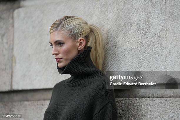 Devon Windsor wears slicked-back blonde hair pulled into a low bun with a deep side part, a white embossed crocodile pattern leather structured...