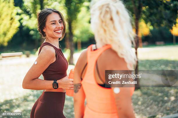 hermosas mujeres diabéticas corriendo en el parque con monitor continuo de glucosa - diabetes fotografías e imágenes de stock
