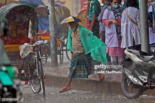 Working people suffer in the rain in Dhaka, Bangladesh, on October 7, 2025.