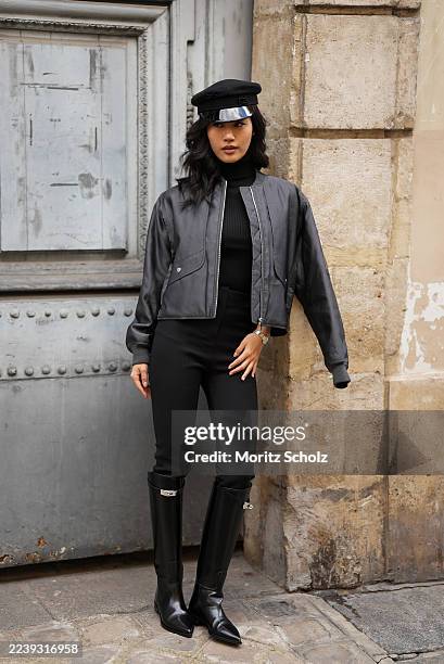 Jihoon Kim is seen wearing a full Look from Hermes including a black knitted high-neck sweater; a black bomber jacket with zip details, oversized cut...