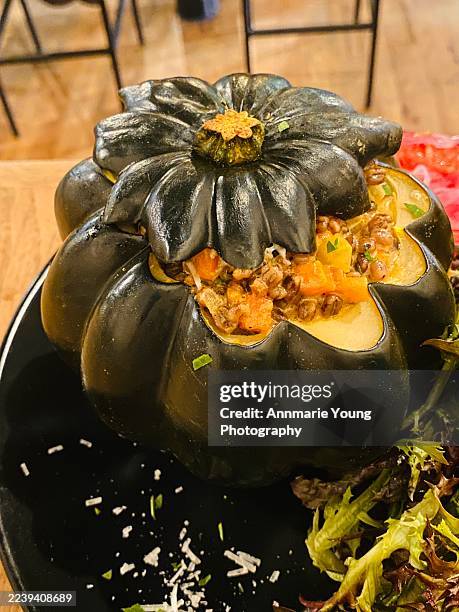 baked acorn squash stuffed with barley and vegetables - stuffed acorn squash stock pictures, royalty-free photos & images