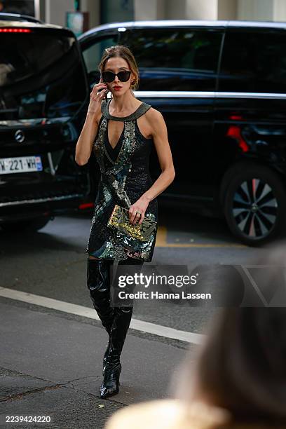 Guest is seen wearing Karen Millen sequin dress, sequin clutch, black sunglasses, black over the knee boots outside Valentino during the Womenswear...