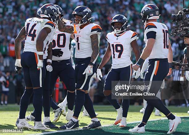 Evan Engram of the Denver Broncos celebrates his touchdown reception with teammates Courtland Sutton, Marvin Mims Jr. #19 and Bo Nix during the...