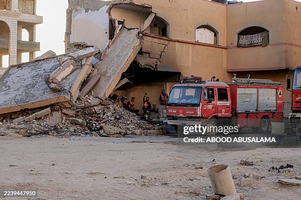Palestinian Civil Defense crews stand near a damaged building in west Gaza City on October 7, 2025. Displaced Palestinians endure harsh conditions...