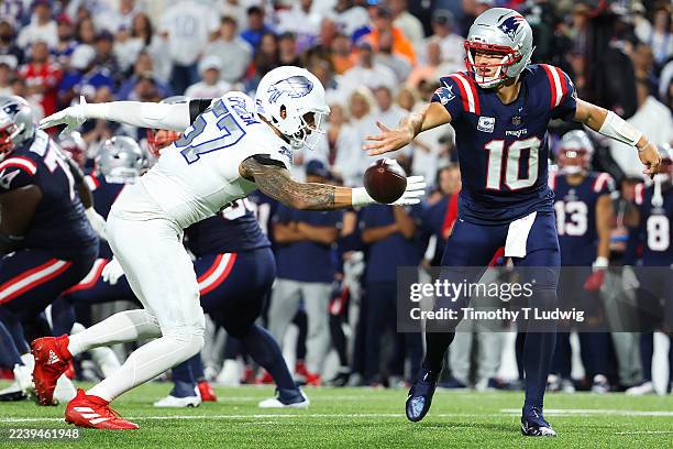 Drake Maye of the New England Patriots throws the ball away while under pressure from A.J. Epenesa of the Buffalo Bills in the first quarter of the...