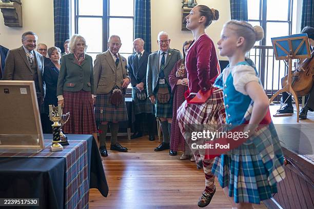 King Charles III and Queen Camilla watch some Highland dancing during a visit to mark the 150th anniversary of The Albert Hall in Aberdeenshire on...