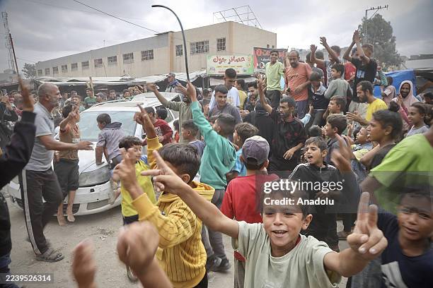 Palestinians, including children, gathered in the city of Khan Yunis celebrate after the announcement of the ceasefire agreement in Gaza on October...