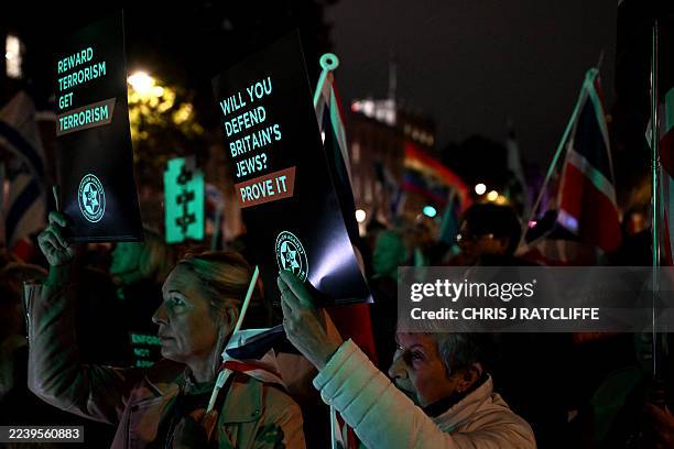 Protesters wave flags and hold placards during a demonstration organised by the Campaign Against Antisemitism outside Downing Street in London on...