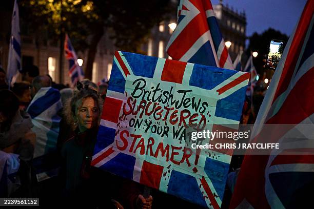 Protesters wave flags and hold placards during a demonstration organised by the Campaign Against Antisemitism outside Downing Street in London on...