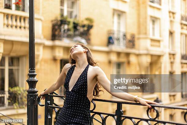 beautiful young woman standing in a street in paris - sleeveless dress stock pictures, royalty-free photos & images