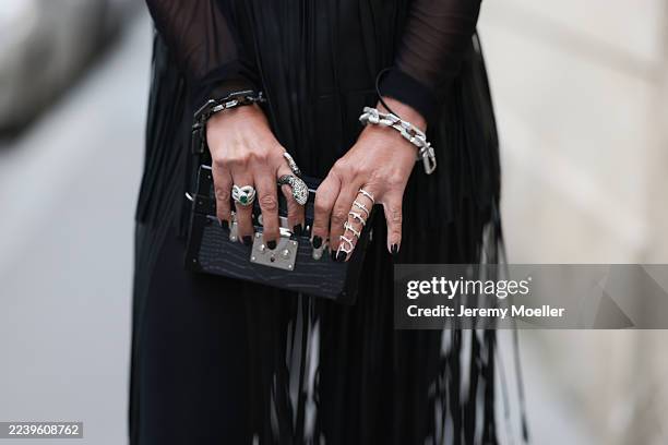 Corina Mihaila Larpin seen wearing a black fringe Kobi Halperin dress over a sheer black long-sleeved top, black leggings, Stefere jewelry, and...