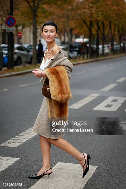 Amalie Gassmann is seen wearing taupe knit jacket, white top, brown Miu Miu bag, brown fur, taupe midi knit skirt and black kitten heels outside Miu...