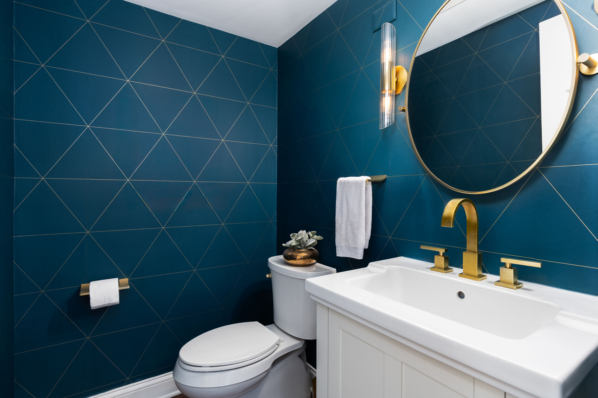 A bathroom with a blue and gold wallpaper and white cabinet. A bathroom with a blue and gold wallpaper and white cabinet.