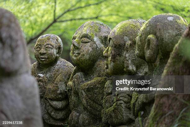 moss-covered stone statues of rakans, - shinto stock pictures, royalty-free photos & images