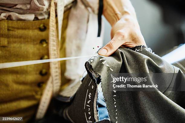 close up shot female tailor hand sewing sleeve opening in workshop - couture visible photos et images de collection