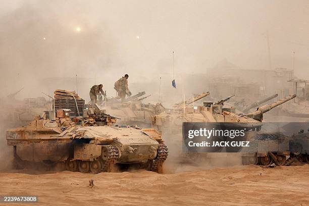 An Israeli army infantry-fighting vehicle deploys next to main battle tanks at a position along the Israel-Gaza border fence on October 10, 2025....