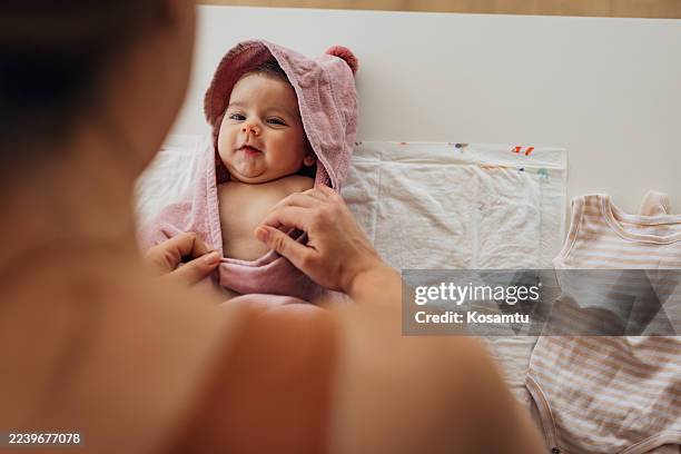 primer plano de una dulce niña envuelta en una toalla con capucha después de la hora del baño - envuelto en una toalla fotografías e imágenes de stock