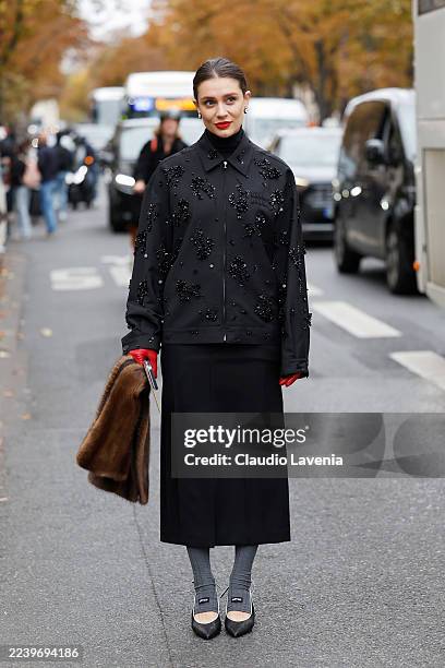 Kate Sardarov wears black Miu Miu jacket with sequins decorations, black long pencil skirt, grey Miu Miu socks, black kitten heels, red leather...