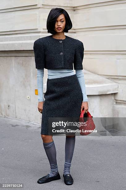 Guest wears light blue long sleeves top, dark grey wool short sleeves cropped jacket with matching midi skirt, grey socks, black Miu Miu loafers, red...