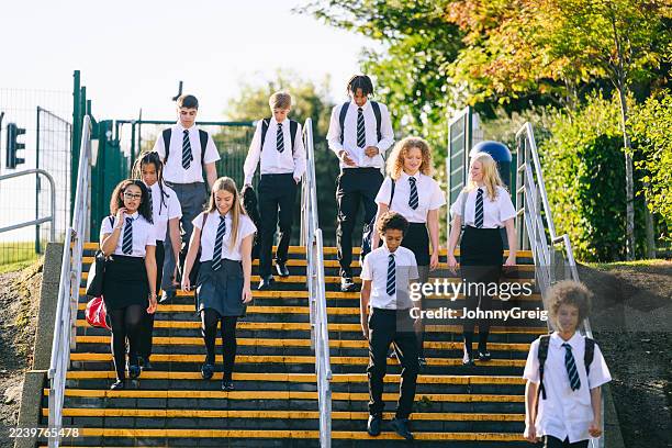 high school girls and boys wearing uniform walking down steps on way to school - school uniform uk stock pictures, royalty-free photos & images