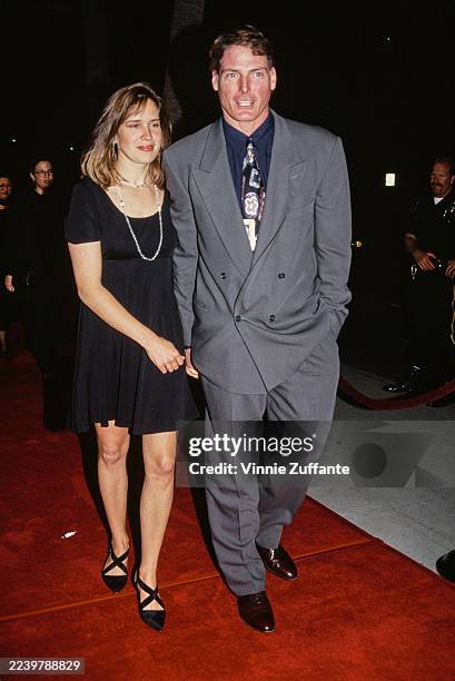 American actress and singer Dana Reeve, wearing a short-sleeve black dress, and her husband, American actor Christopher Reeve, who wears a grey suit...