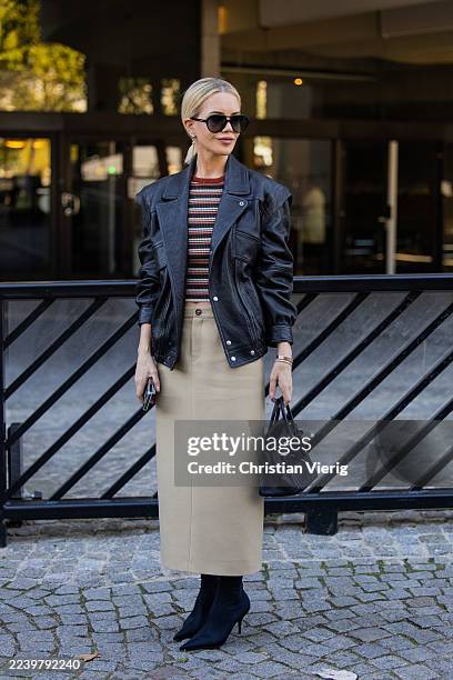 Guest wears black leather jacket, Hermes bag, beige skirt outside Christopher Esber during the Womenswear Spring Summer 2026 as part of Paris Fashion...