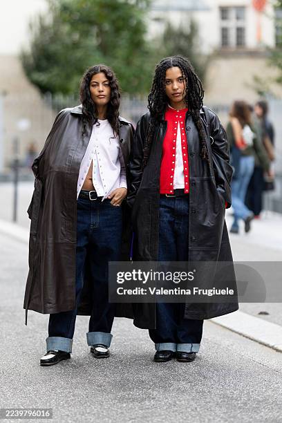 Guest wears on the left a white cardigan, a brown leather trench coat, a black leather belt, blue low waist jeans and black and white leather loafers...