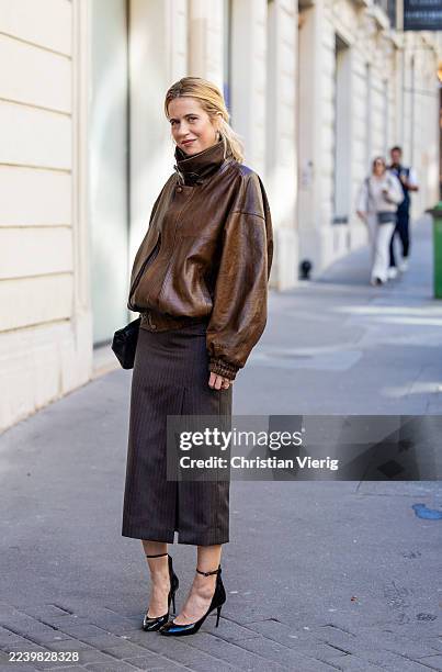 Christine Wuerfel-Stauss / Christine Würfel-Stauss wears slit pencil skirt Saint Laurent, brown leather bomber jacket Magda Butrym, patent leather...