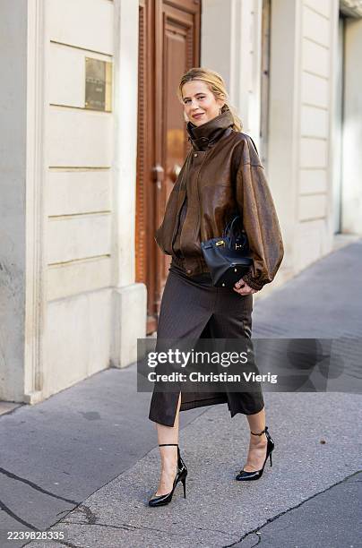 Christine Wuerfel-Stauss / Christine Würfel-Stauss wears slit pencil skirt Saint Laurent, brown leather bomber jacket Magda Butrym, patent leather...