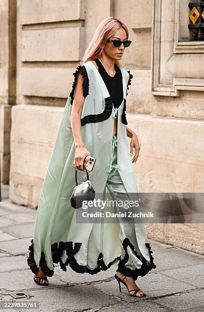 Tina Leung is seen wearing a green and black Meryll Rogge dress, black heels, mini bag and black sunglasses outside the Meryll Rogge show during the...