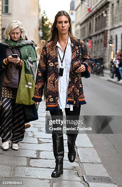 Guest is seen wearing a black and pink sweater, black pants and black knee high boots outside the Meryll Rogge show during the Womenswear Spring...