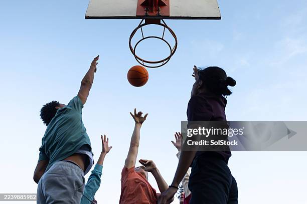 competitive teens jumping for basketball - team sport stock pictures, royalty-free photos & images