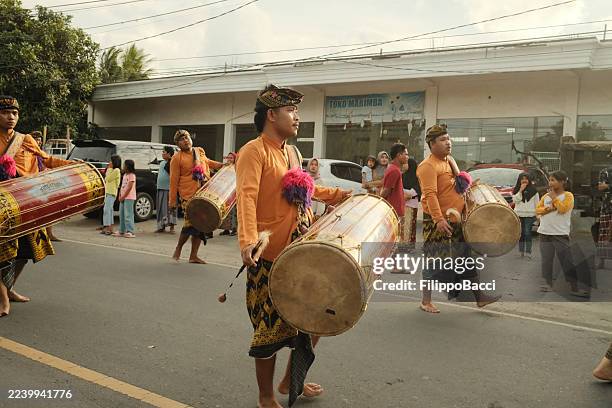 hombres indonesios desfilando tambores en celebración tradicional - equipo musical fotografías e imágenes de stock