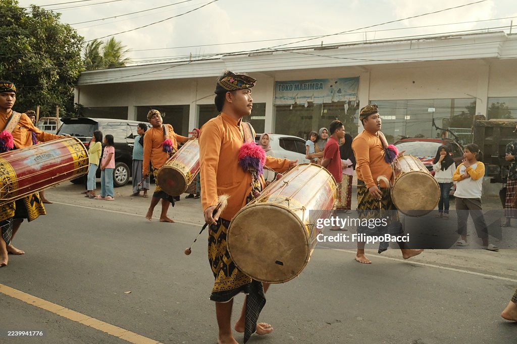 Indonesian men parading drums in traditional celebration