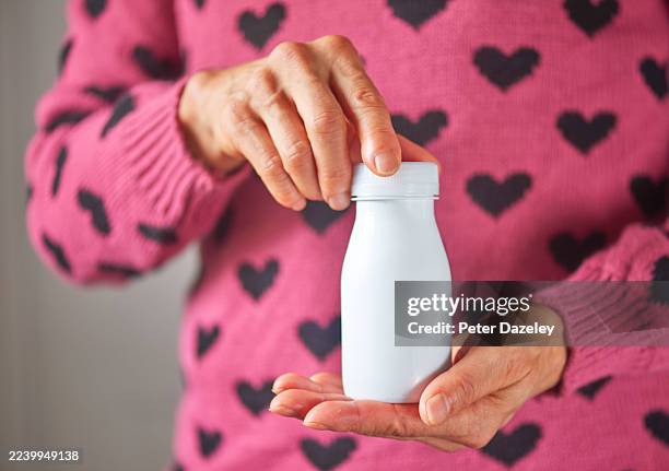 holding a bottle of probiotic drink . - organismo acidófilo imagens e fotografias de stock