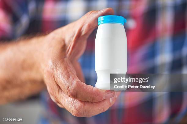 holding a bottle of probiotic drink . - organismo acidófilo imagens e fotografias de stock