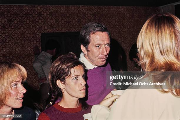 American singer Andy Williams, wearing a purple knitted sweater, with his partner Franco-American singer and actress Claudine Longet, who wears a...