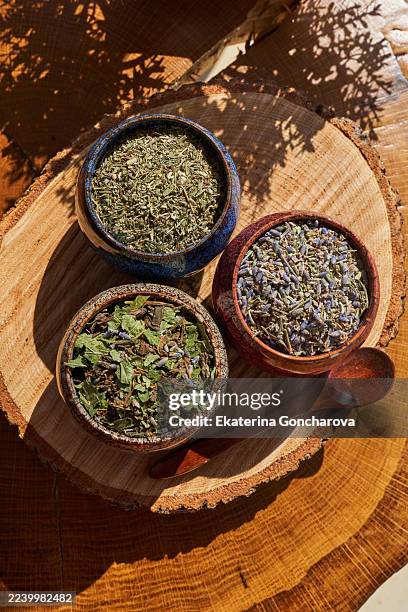wooden display hosting herbal bowls with sunlight and shadows - kruidentuin stockfoto's en -beelden